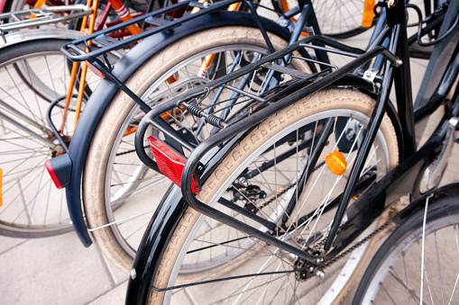 Närbild på bakhjulet och pakethållaren på flera cyklar på en rad.